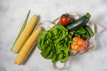 Paper and cotton bag of healthy vegetables, flat lay food on the table. Top view, copy space.