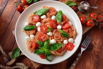 Italian Colorful Pasta dish or Spaghetti Napolitana with cherry tomatoes, vegan mozzarella and basil 
