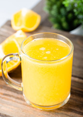 glass of fresh orange juice with fresh fruits on wooden table