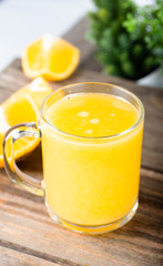 glass of fresh orange juice with fresh fruits on wooden table