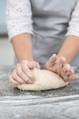 Woman`s hands making dough in the kitchen at home