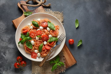 Fototapeta na wymiar Italian Colorful Pasta dish or Spaghetti Napolitana with cherry tomatoes, vegan mozzarella and basil 