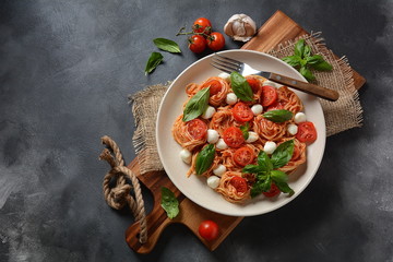 Italian Colorful Pasta dish or Spaghetti Napolitana with cherry tomatoes, vegan mozzarella and basil 