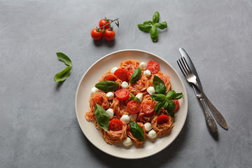 Italian Colorful Pasta dish or Spaghetti Napolitana with cherry tomatoes, vegan mozzarella and basil 