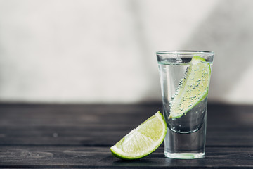 fresh tequila with lime on wooden surface