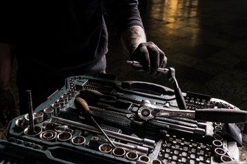 Detail of the hands of a mechanic taking a screwdriver from a toolbox