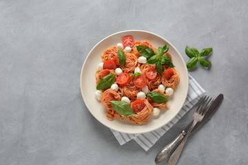 Italian Colorful Pasta dish or Spaghetti Napolitana with cherry tomatoes, vegan mozzarella and basil 