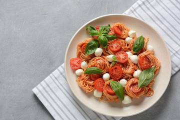 Italian Colorful Pasta dish or Spaghetti Napolitana with cherry tomatoes, vegan mozzarella and basil 