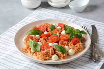 Italian Colorful Pasta dish or Spaghetti Napolitana with cherry tomatoes, vegan mozzarella and basil 