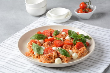 Italian Colorful Pasta dish or Spaghetti Napolitana with cherry tomatoes, vegan mozzarella and basil 