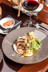 Salad with roasted duck breast and orange with white napkin on wooden table at restaurant
