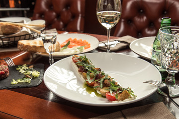 octopus salad with potatoes and cherry tomatoes on wooden table at restaurant