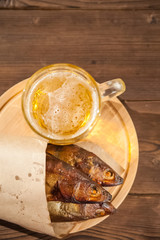 Beer glass with beer and hot smoked fish close-up. Beer mug with beer and fish on a dark background and copy space.