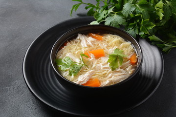 Chicken soup with noodles and vegetables in bowl. Healthy food concept
