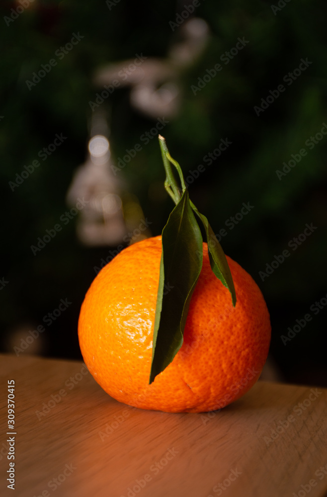 Wall mural orange mandarin on christmas tree background