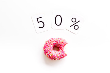 50 off discount - sale concept with bitten donut - on white background top-down copy space