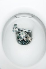 top view of dollar banknotes in toilet bowl