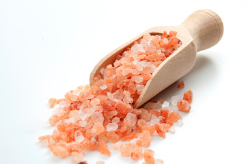 Fototapeta na wymiar Wellness spa therapy, healthy sodium supplement and therapeutic use of natural minerals conceptual idea with heap of coarse himalayan pink sea salt in wooden scoop isolated on white background