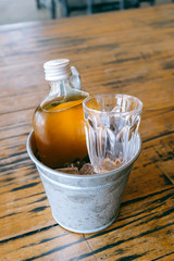 Cold brew tea bottle in ice bucket with glass
