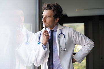 Doctor being thoughtful looking through window