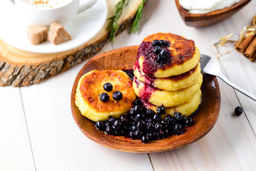 Fritters of cottage cheese with blueberries in plate, closeup