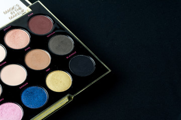 Make-up colorful eyeshadow palettes isolated on black background. View from above. 