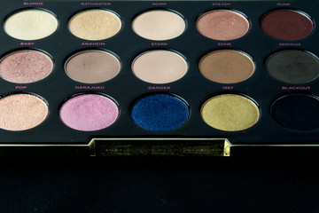 Make-up colorful eyeshadow palettes isolated on black background. View from above. 