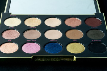 Make-up colorful eyeshadow palettes isolated on black background. View from above. 