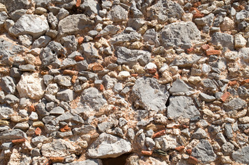 Colorful ancient stone wall with pieces of ceramics  closeup