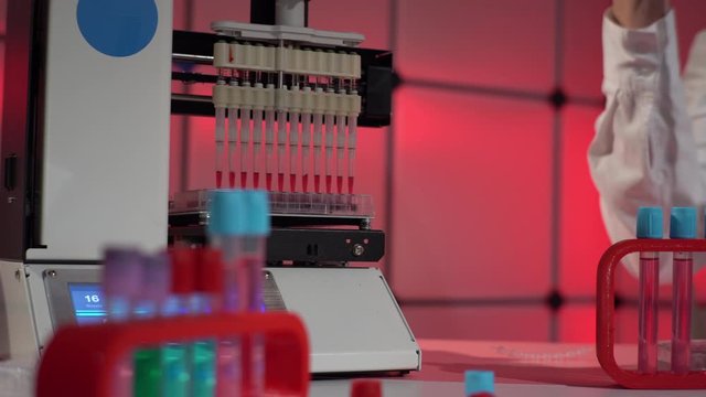 Young woman use Automated DNA Processor real-time PCR cycler.  PCR robotic machine for molecular and genetic research laboratory