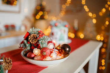 Beautiful holiday decorated kitchen with Christmas tree and bright lights , holiday glasses on the main plan, blur background