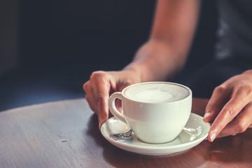 hands hold hot cup of coffee in the coffee shop.
