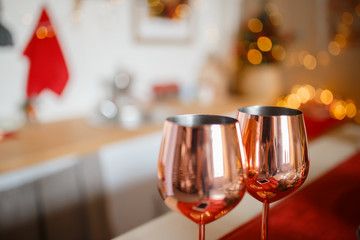 Beautiful holiday decorated kitchen with Christmas tree and bright lights , holiday glasses on the main plan, blur background