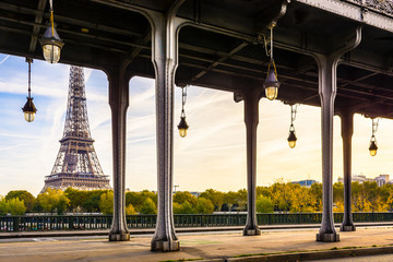 The Eiffel tower in Paris seen from the Bir-Hakeim bridge by a sunny morning with the glass globes...