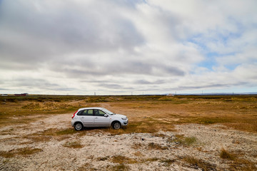 Obraz na płótnie Canvas Tundra landscape with moss, glass and stouns in the north of Norway or Russia, car in it and blue sky with clouds
