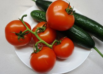 red tomatoes and green cucumbers on a plate.......