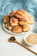 Cookies with cottage cheese and sugar on a light plate on a light background with a blue napkin free copy space.