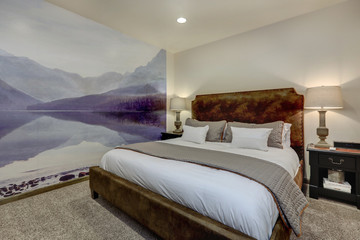 Cozy small but luxury guest bedroom with white bedding and browns suede bed and purple mural of the mountains.