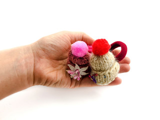 Hats in hand isolated on white background. Elastic bands for hair in the form of winter hats. Set of hats. Set of rubber bands for hair. Knitted hats. Elastics for hair. 