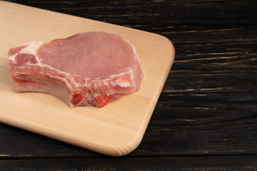 Top view of one pieces raw pork chop steaks on a cutting board.