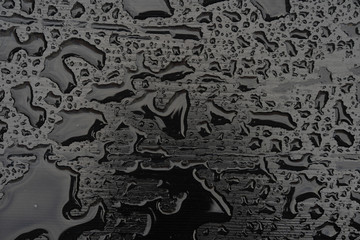 Rain water drops on black surface