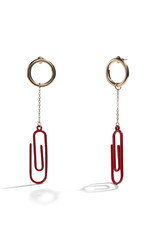 Close-up subject shot of a pair of stud earrings on the white background. Each earring is made as a golden ring with a stylized red paperclip on the golden chain.