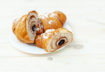 Fresh Croissant with chocolate on the white wooden background