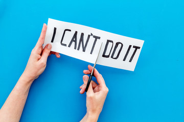 Motivation to self-developing. Hands cutting text I can't do it with scissors on blue background