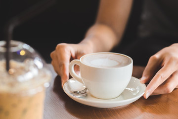 hands hold hot cup of coffee in the coffee shop.