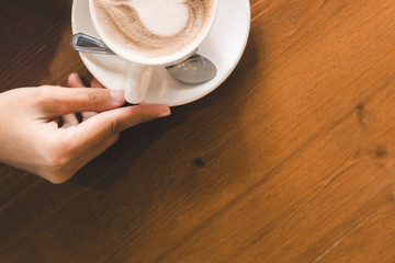 hands hold hot cup of coffee in the coffee shop.