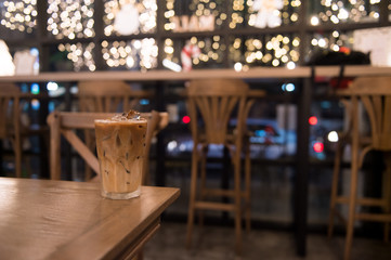ice latte coffee in plastic cup put on wooden table, christmas theme background