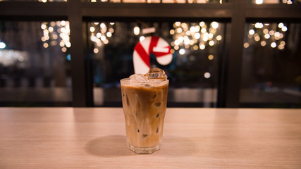 ice latte coffee in plastic cup put on wooden table, christmas theme background