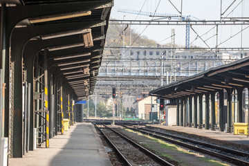 Old and crumbling tracks on the platforms of a train station in a capital city of Central Europe, with rusted metal and signalling in the background