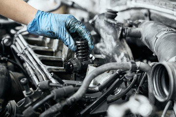 Fototapeta Professional mechanic checking nozzle in diesel car engine obraz